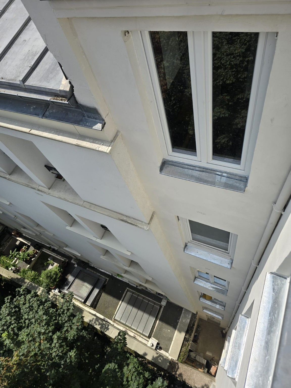 Vue plongeante sur la façade de courette rénovée et les appuis en zinc
