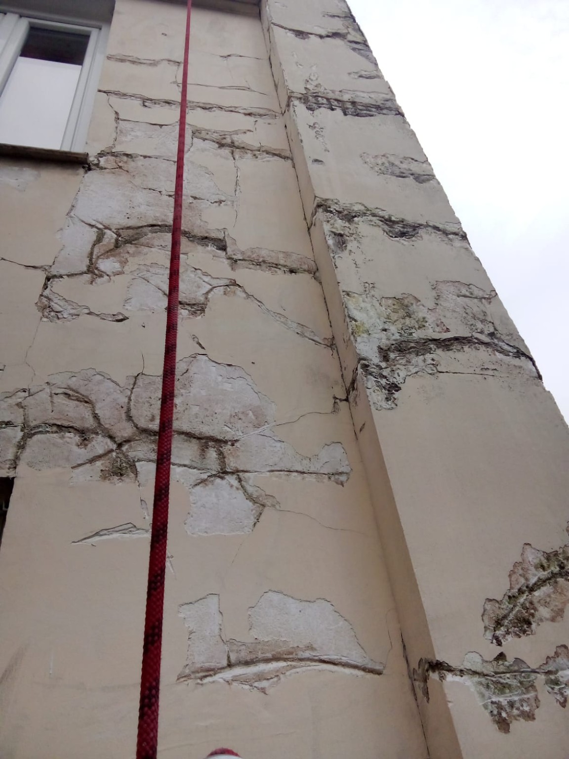 Façade de courette présentant des enduits dégradés avant intervention