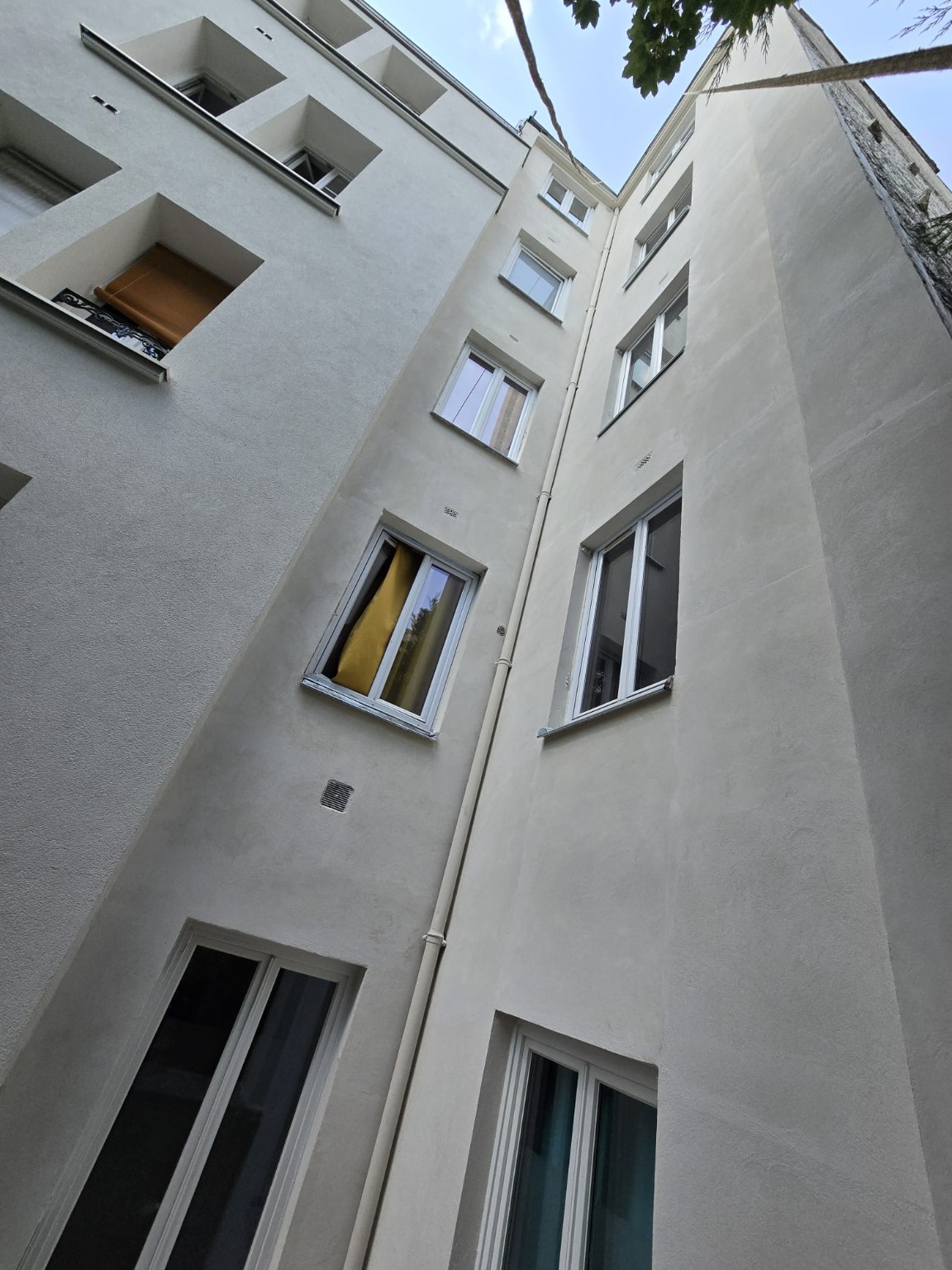 Façades de courette rénovées et appuis de fenêtres en zinc après travaux